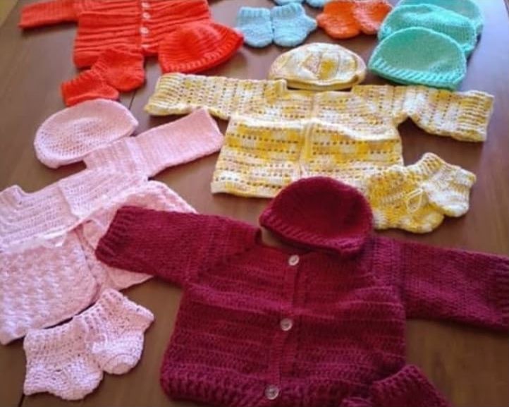 Sets of crochet baby clothes: cardigans, hats and booties